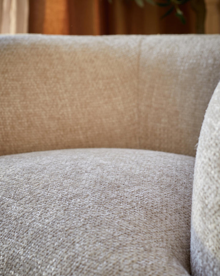 Close up of a beige tweed couch, focusing on the seat and back. Soft, inviting texture visible.