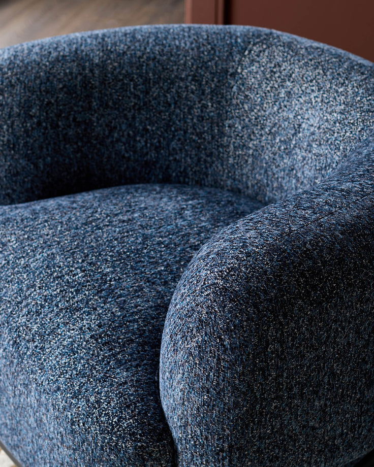Florence armchair in navy weave fabric, close-up detail showing textured upholstery and curved armrest design.