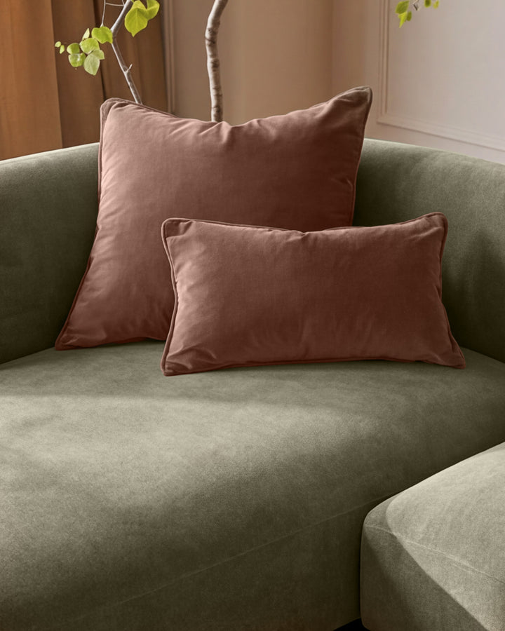 Florence left-hand chaise sofa in olive green fabric with mauve velvet pillows and decorative branches.