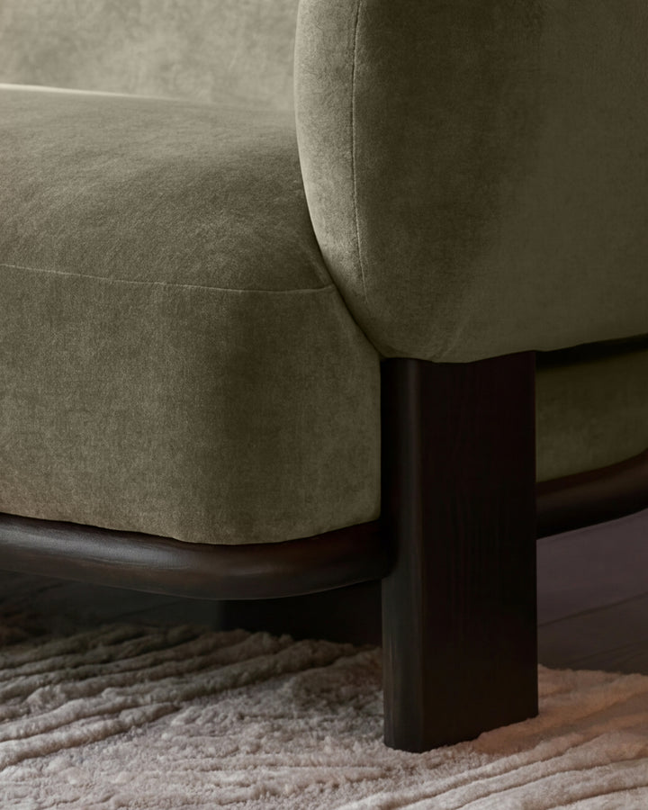 Florence left-hand chaise sofa in olive green fabric with dark wood legs, shown from side angle on neutral rug.