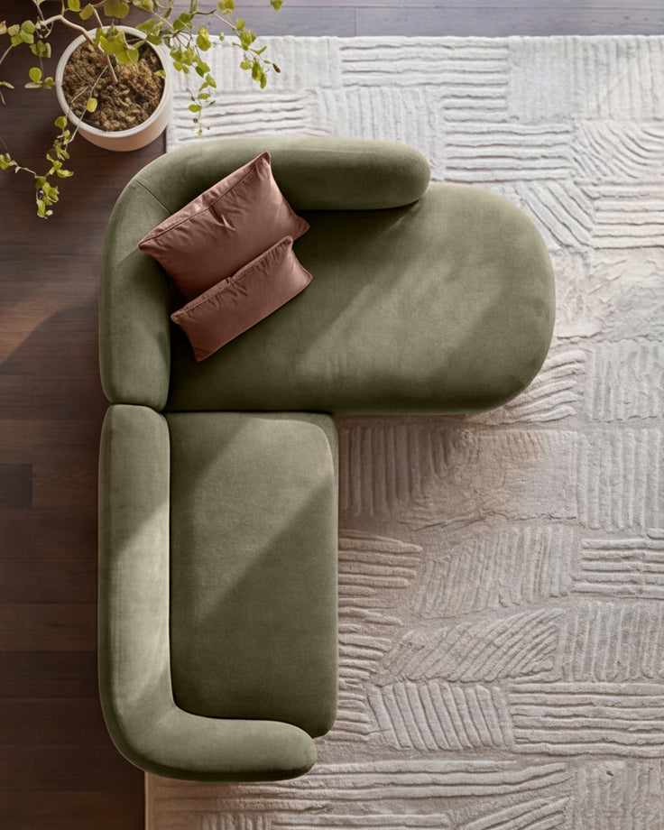 Florence right-hand-facing chaise sofa in olive green fabric with burgundy pillows, viewed from above on textured rug.