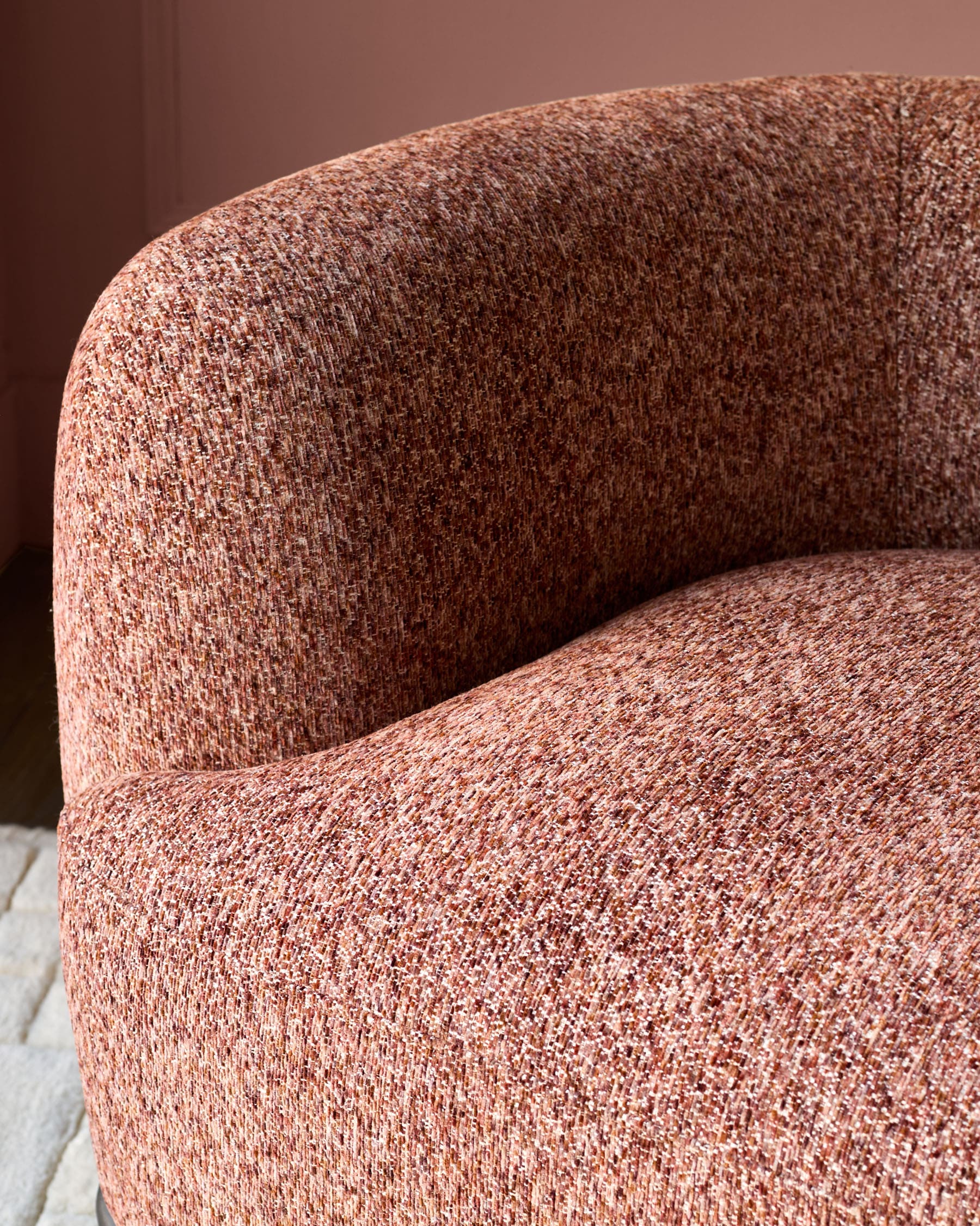 Florence armchair in toffee-red weave fabric, close-up of curved backrest and seat showing textured upholstery detail.
