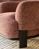 Florence armchair in toffee-red weave fabric with dark wood leg, shown from close-up side angle on neutral rug.