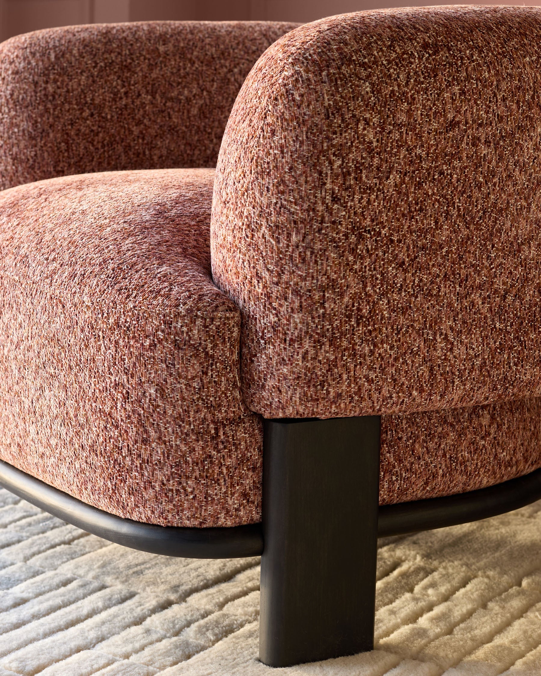 Florence armchair in toffee-red weave fabric with dark wood legs, shown at close-up angle on neutral rug.