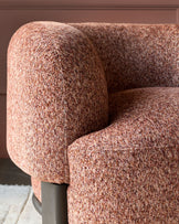 Florence armchair in toffee-red weave fabric, showing curved armrest and rounded seat detail from side angle.