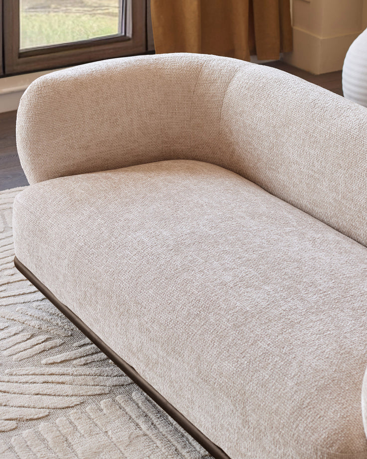 Florence 2-seater sofa in natural fabric with curved backrest and dark wood base, displayed at an angle in a bright room.