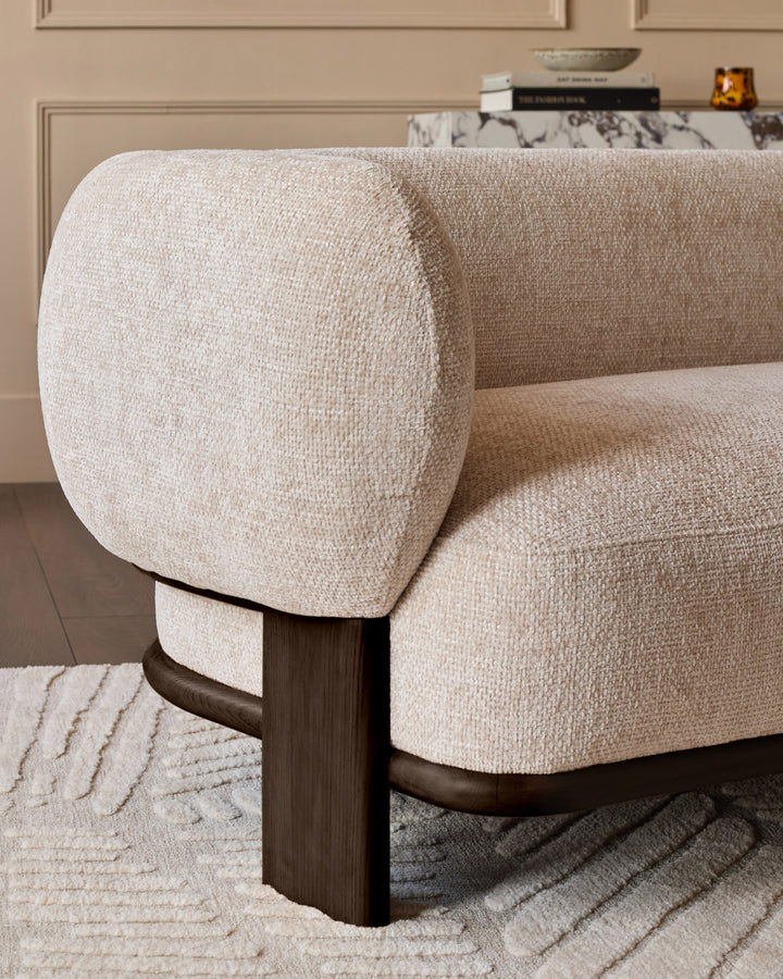 Florence 2-seater sofa with natural fabric upholstery and dark wood legs, shown from side angle highlighting curved armrest.