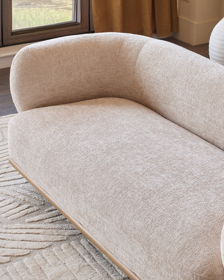 Florence 2-seater sofa in natural linen fabric with curved backrest and natural wood base, angled side view.