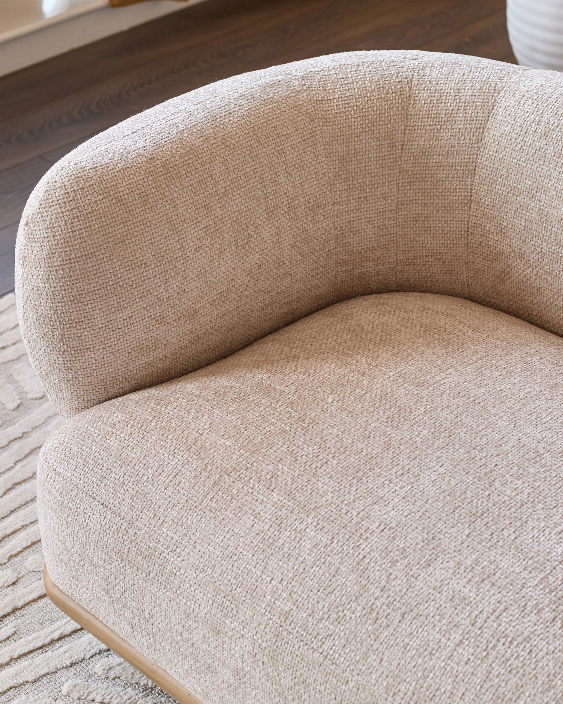 Florence 2-seater sofa in natural fabric with curved back and natural wood base, angled side view.