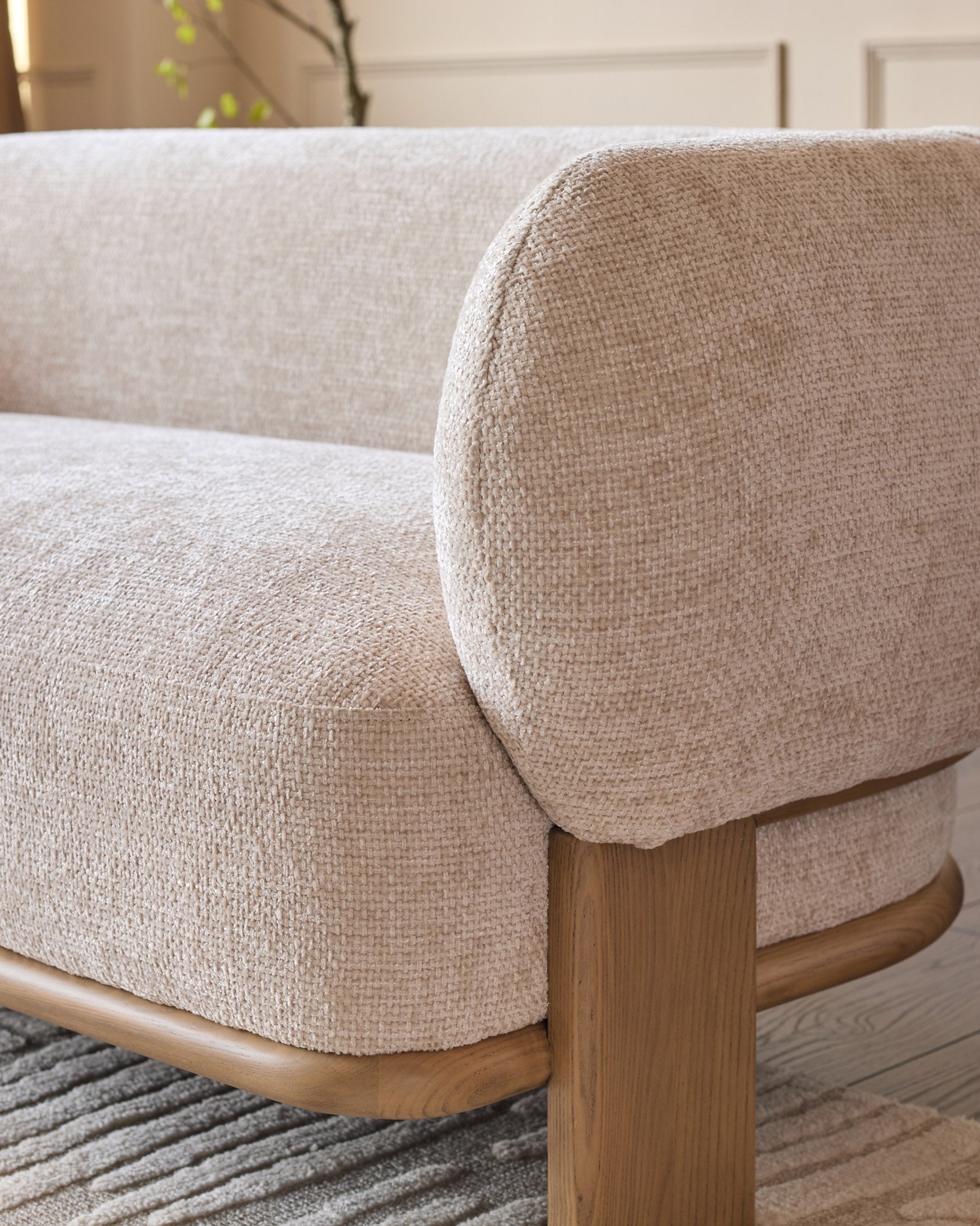 Florence 2-seater sofa close-up showing natural wood frame, rounded armrest, and beige fabric upholstery