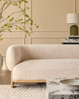 Florence 2-seater sofa in natural wood and beige fabric, shown in a styled living room setting with curved armrests and rounded design.