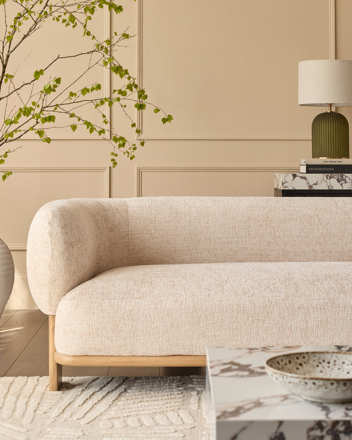 Florence 2-seater sofa in natural wood and beige fabric, shown in a styled living room setting with curved armrests and rounded design.