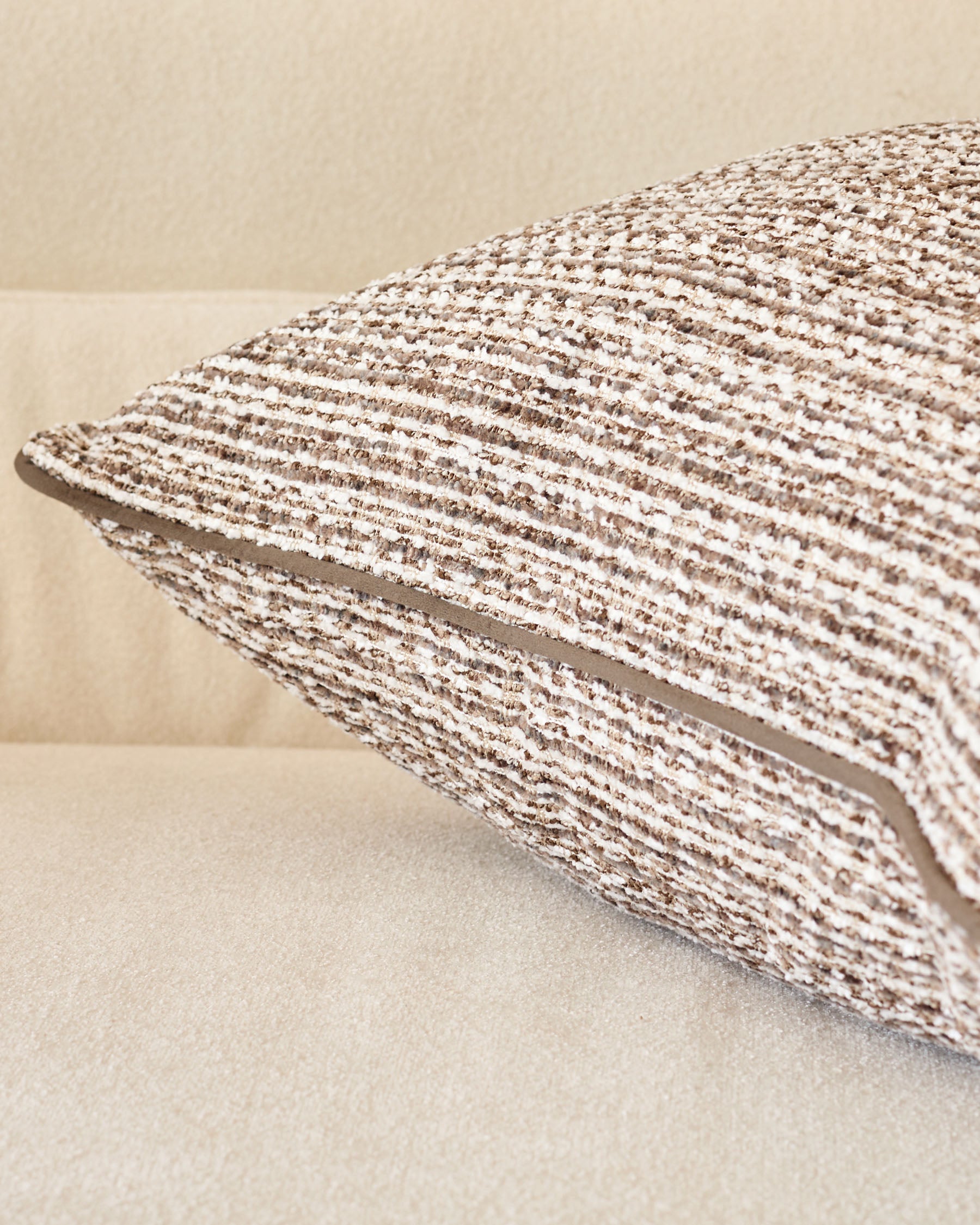 Large chocolate Franco cushion with textured woven fabric, angled side view showing dimensional piping detail.