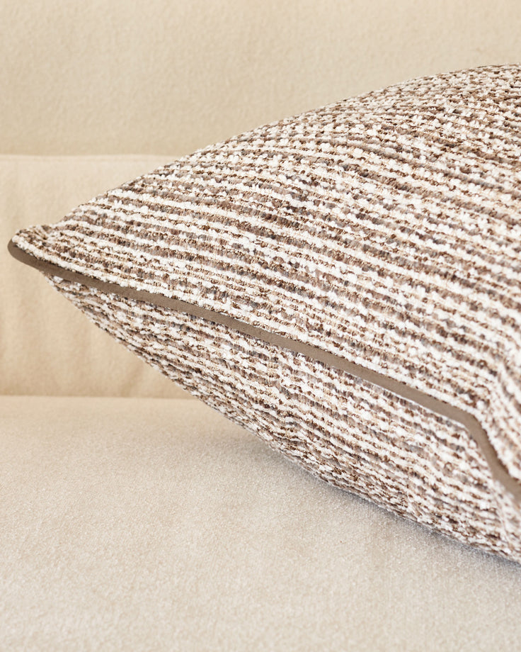 Large chocolate Franco cushion with textured woven fabric, angled side view showing dimensional piping detail.