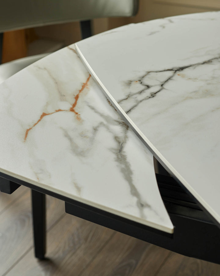 Close-up of a marble effect dining table with a black frame and additional leaf.