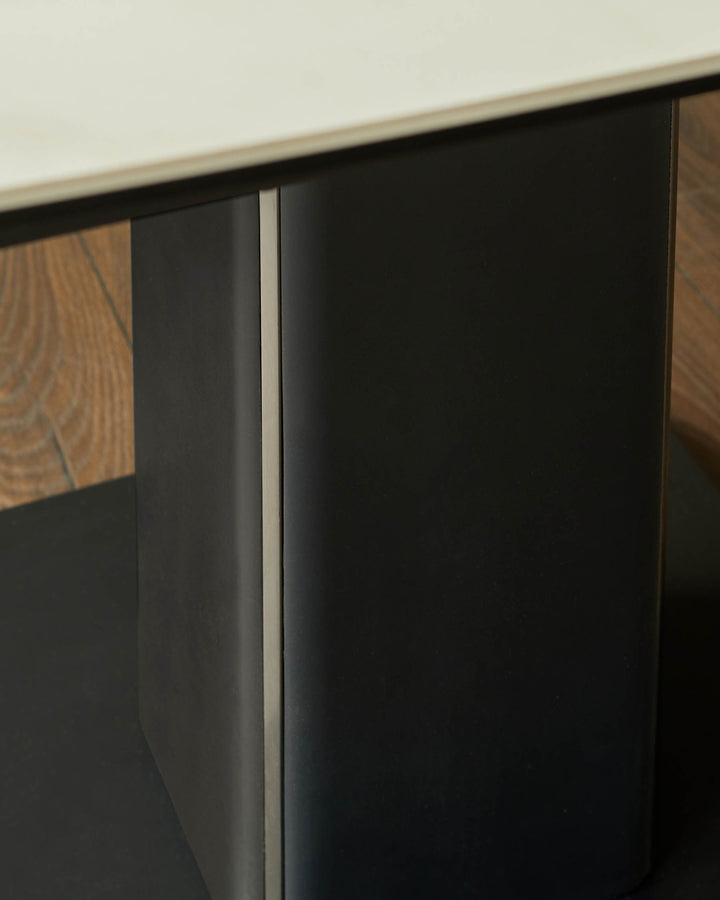 A contemporary table with a light-coloured top and dark grey metal legs. Minimalist and modern design.