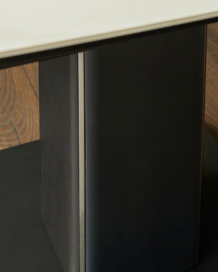 Black sliding door cabinet with wood grain accent panel and brushed metal handle detail.