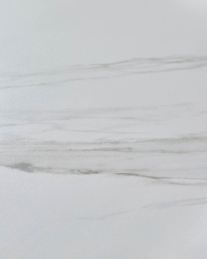 White ceramic dining table surface with wood grain texture detail, close-up view of tabletop finish.
