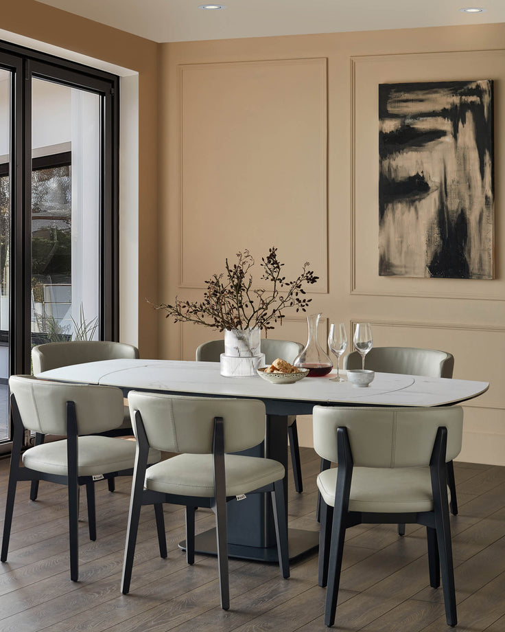 Fraser extending dining table in white ceramic with black base, seated by six cream upholstered chairs in modern dining room.