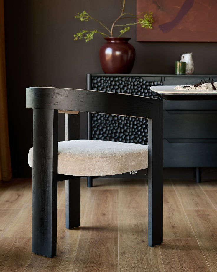 Garcia dining chair in black wood with champagne fabric seat, shown in a modern dining room setting.