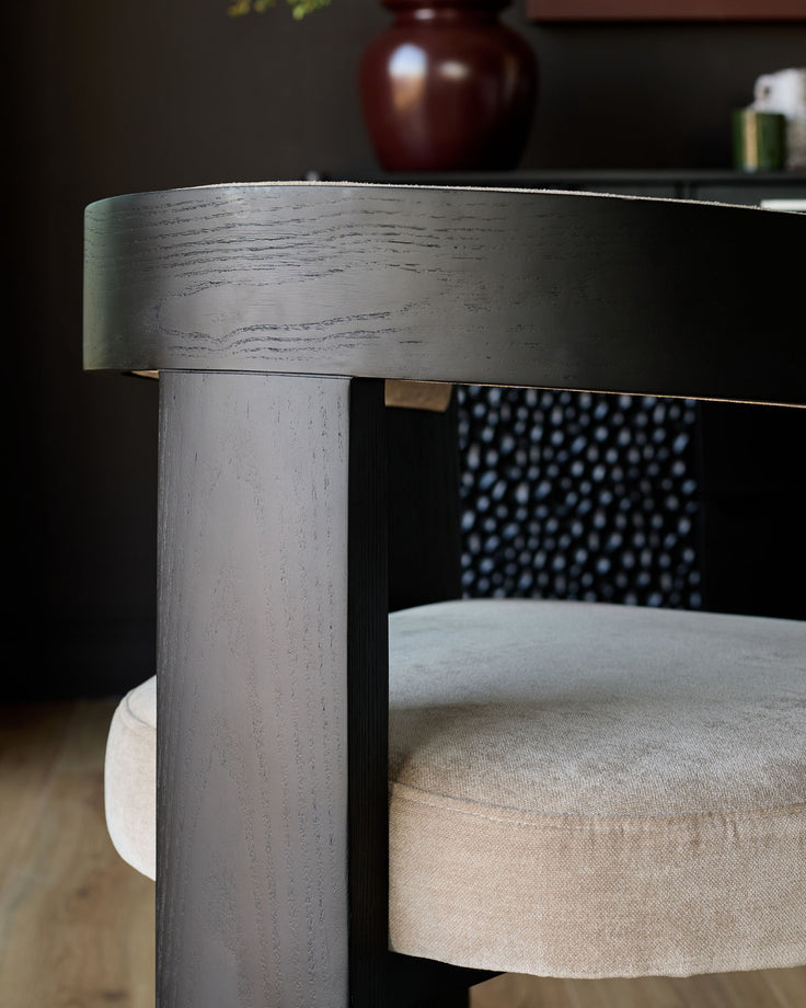 Garcia dining chair in champagne fabric, side angle showing dark wood frame and cylindrical leg detail.