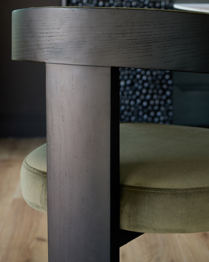 Garcia dining chair in olive green velvet, close-up of wooden leg and seat detail.
