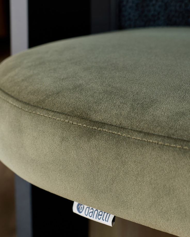 Garcia dining chair in olive green velvet with visible seam detail and designer label tag.