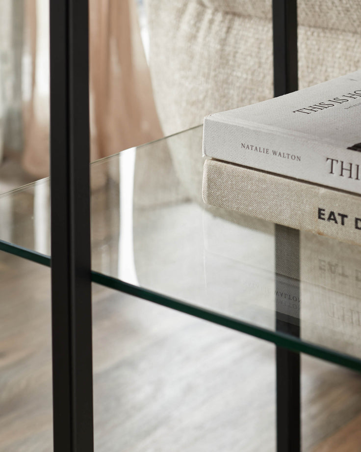 Close-up of a glass shelf with books. Modern furniture design with clean lines and minimalist aesthetic.
