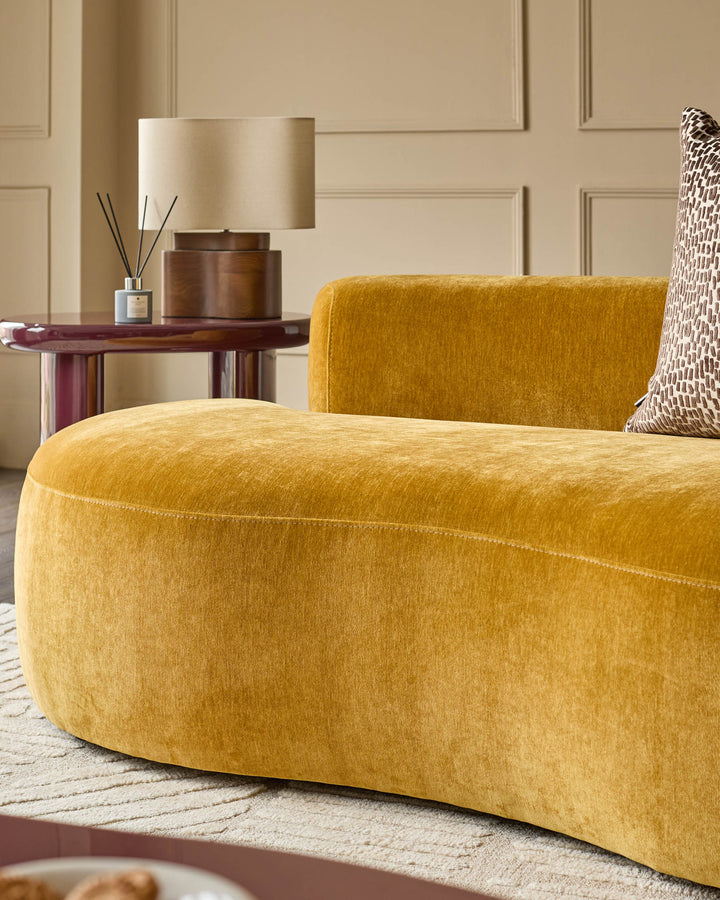 Gianna 2-seater sofa in ochre fabric, shown from side angle in a styled living room setting.