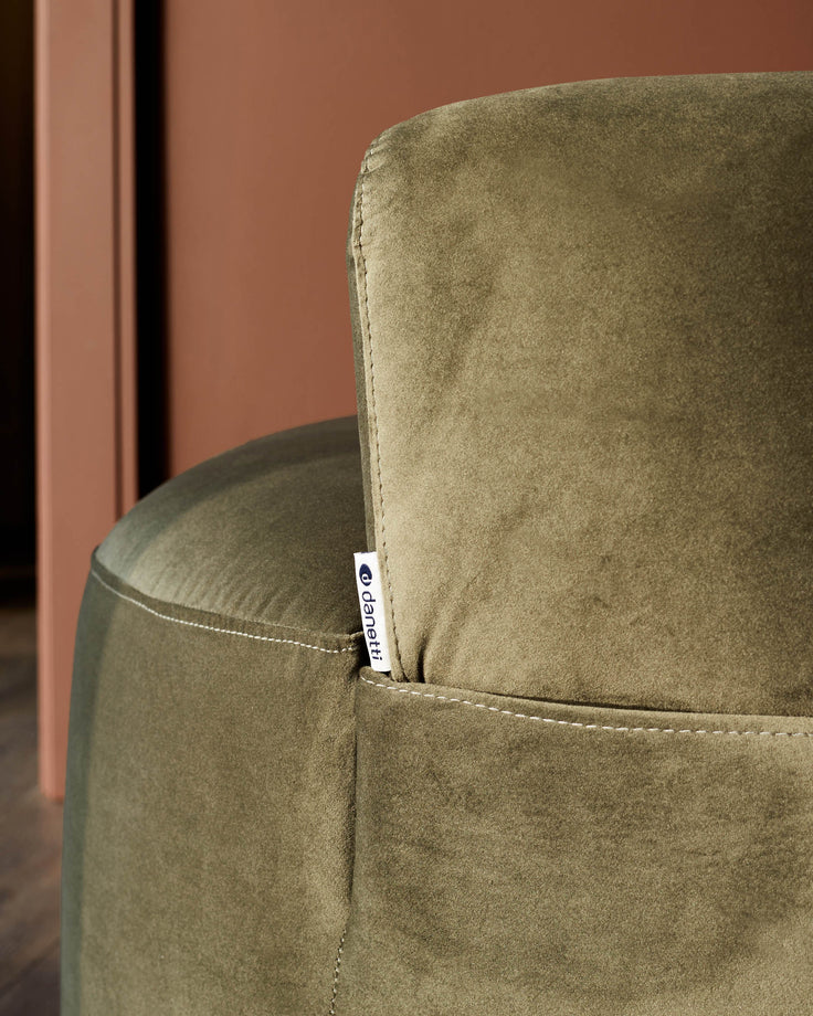 Close-up of a stylish green velvet chair, showcasing its soft texture and elegant design. A touch of comfort for any modern home.