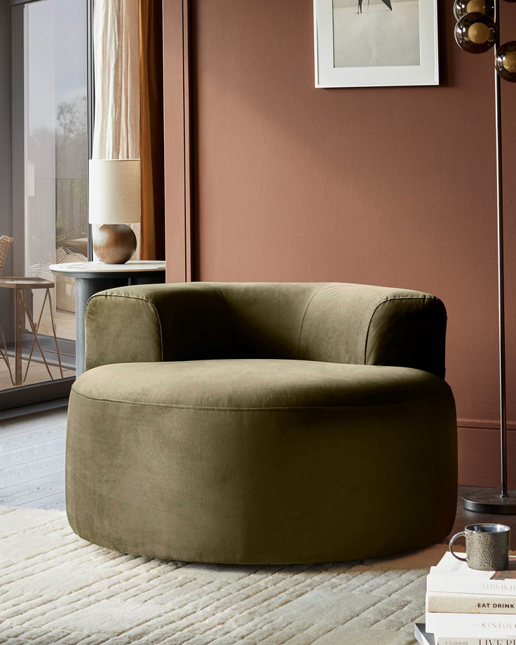 Stylish olive green circular chair on a cream rug, accented by a modern lamp and decorative books. Relax in comfort and style.