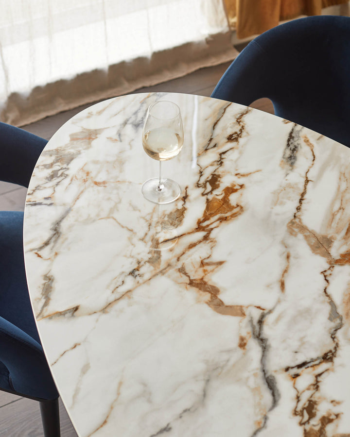 Marble-effect table with a glass of wine. Navy blue chairs and wooden floor. Modern interior design.