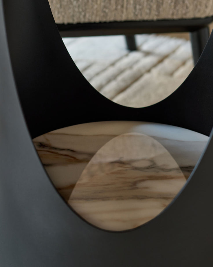Giotto side table in natural ceramic with curved cutout details, viewed from above at an angle.