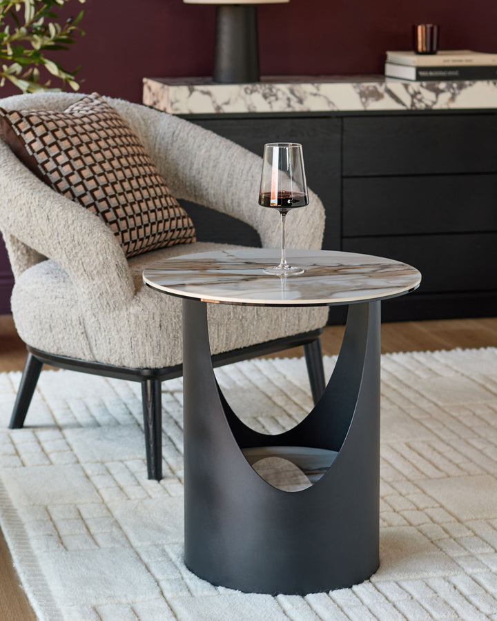 Giotto side table in natural ceramic with cylindrical base and round marble-look top, styled in modern living room setting.