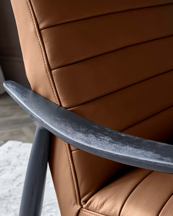Greyson tan leather accent chair detail showing stitched upholstery and dark brushed wood armrest.