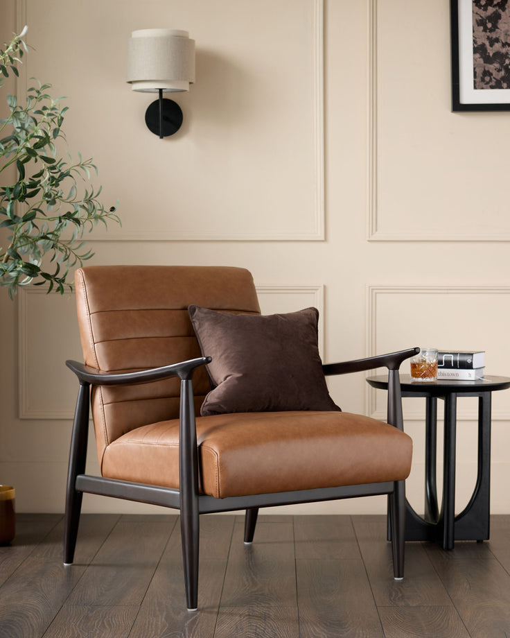 Greyson tan leather accent chair with black wooden frame and arms, styled in a modern living room setting.