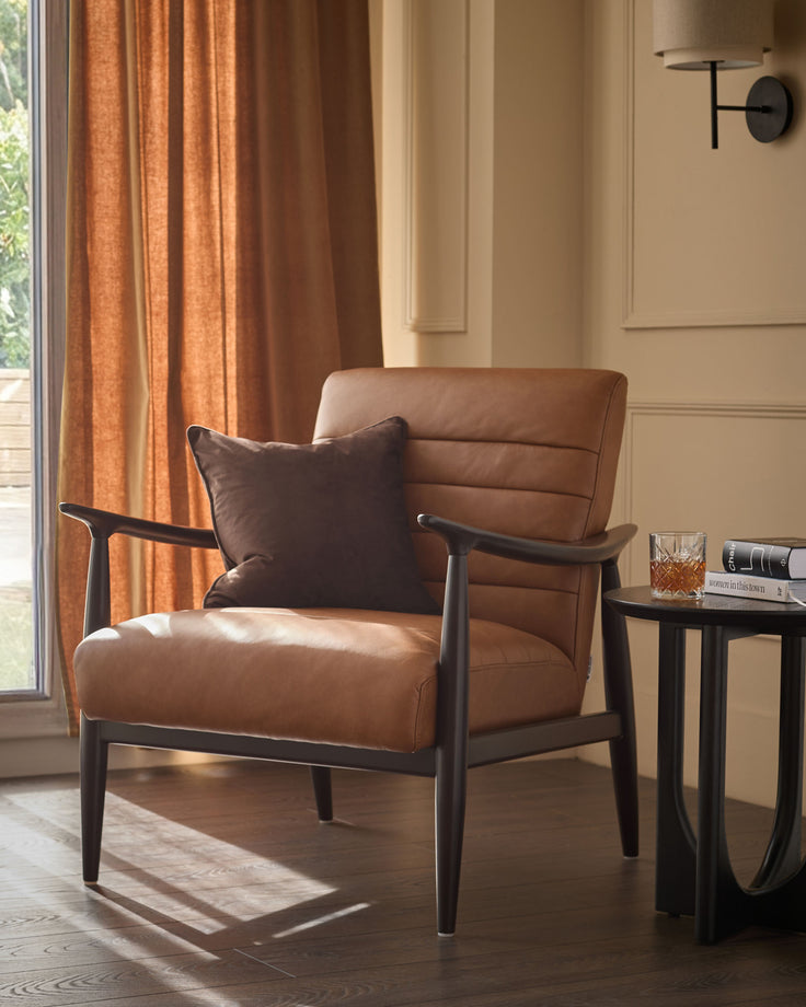 Greyson tan leather accent chair with dark wood frame and armrests, paired with side table in modern living room setting.
