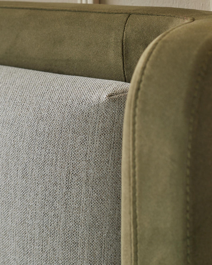 Close up of the fabric detailing on a moss green and neutral coloured sofa.