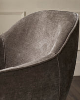 Close-up of a stylish upholstered chair in a neutral shade, showcasing its textured fabric and modern design.