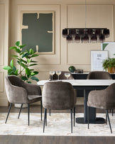 Dining room with marble-top table, velvet chairs, and modern chandelier, exuding elegance and style.