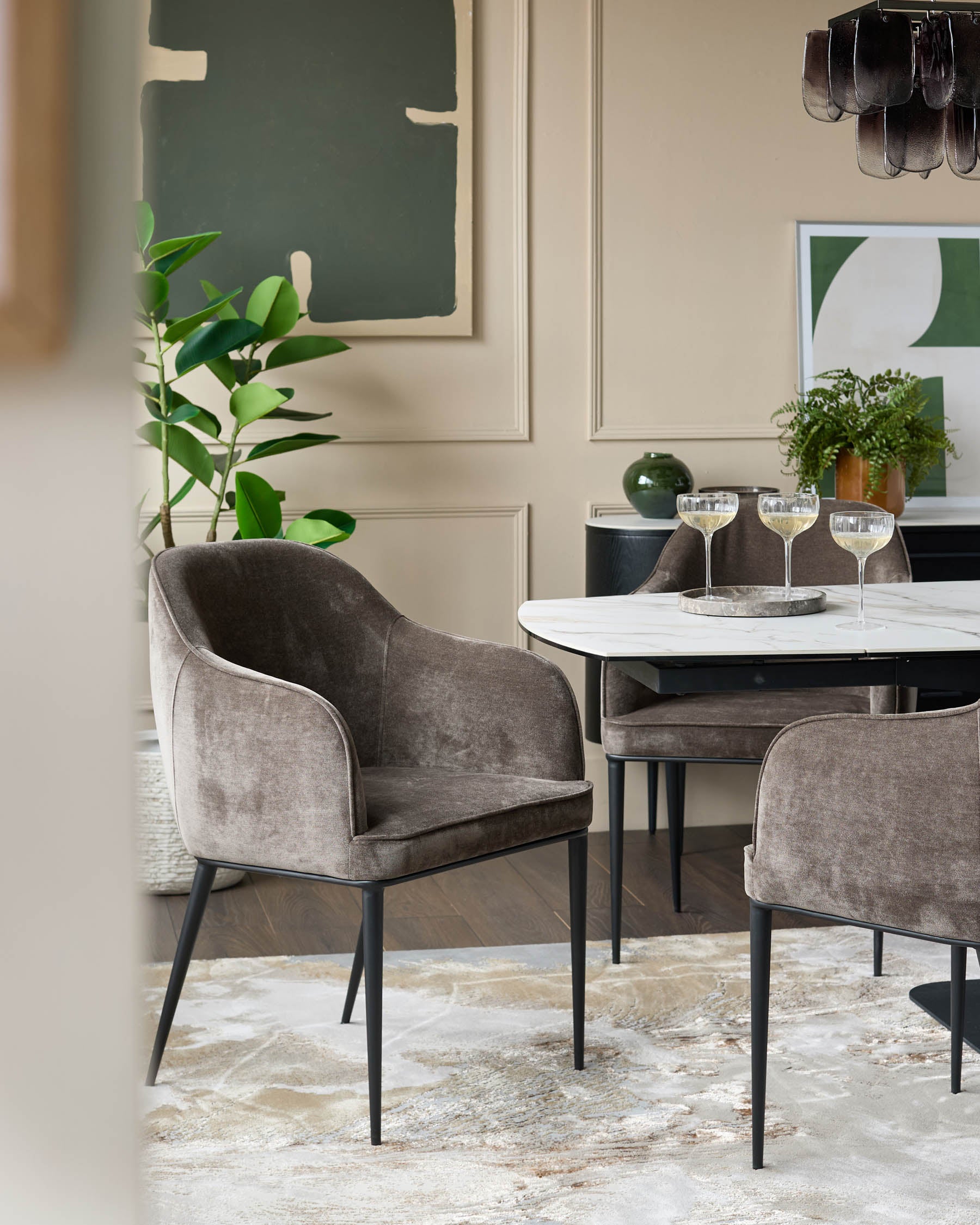 Dining area with upholstered chairs and a modern table. Neutral tones with pops of green.
