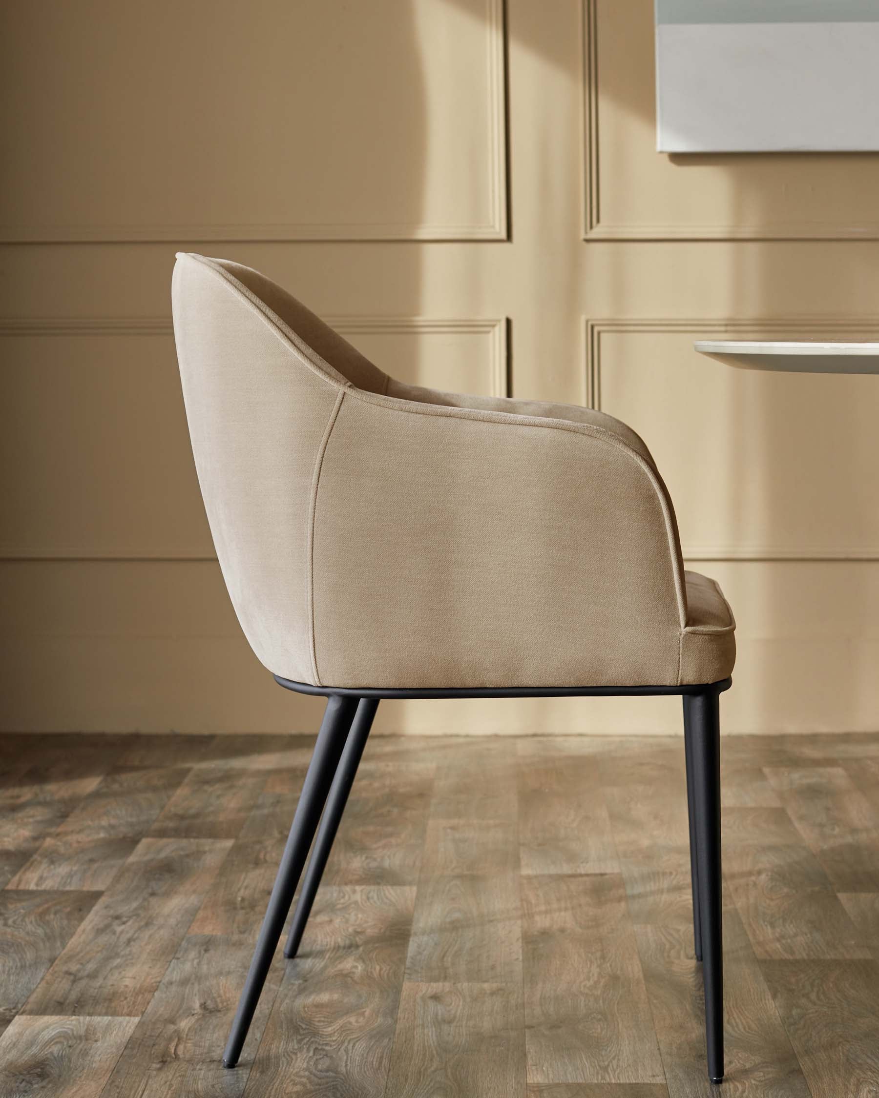 A stylish beige upholstered dining chair with sleek black metal legs, adding a touch of modern elegance to any dining space.