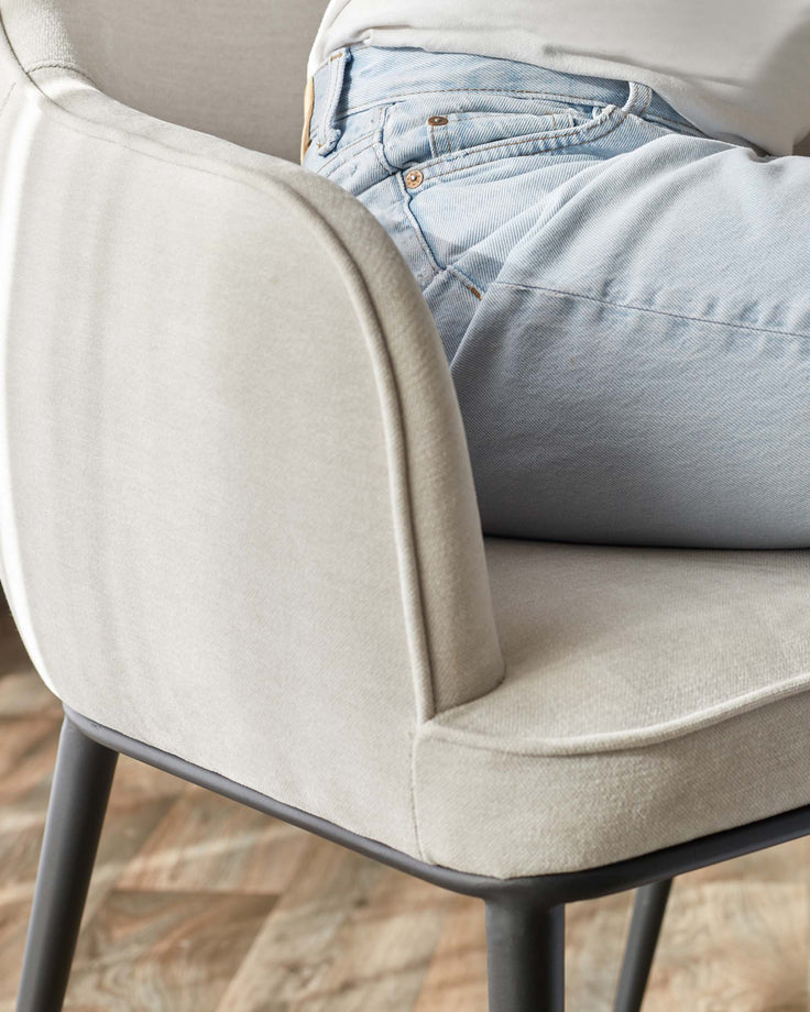 Stylish light grey upholstered chair with dark grey legs. Comfortable seating for any modern home.