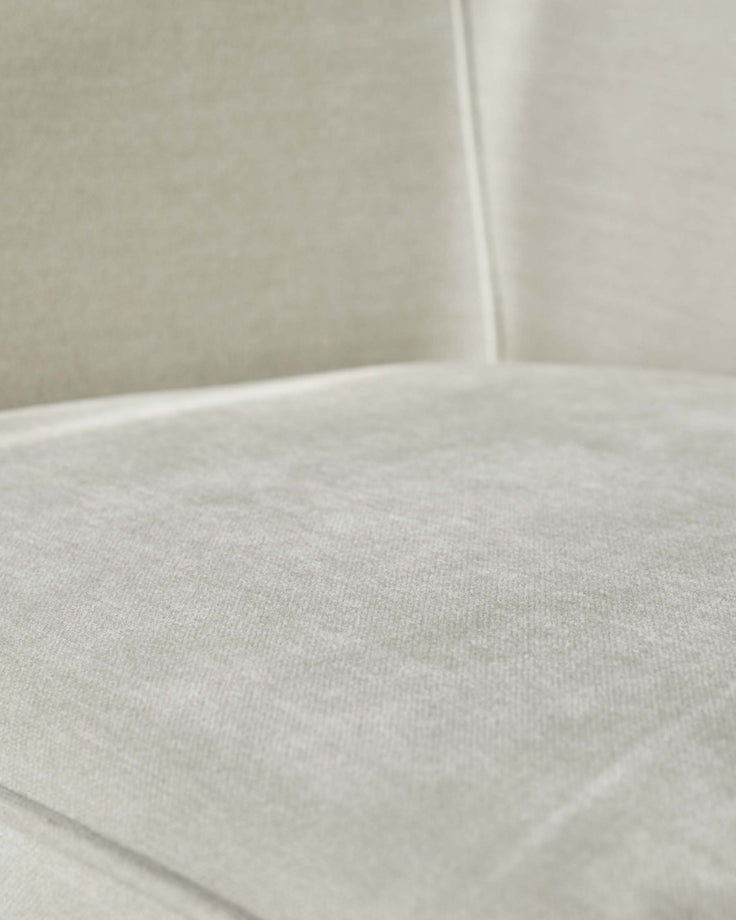Close-up of a cream, textured sofa seat. Soft, inviting, and modern, perfect for a relaxing living space.