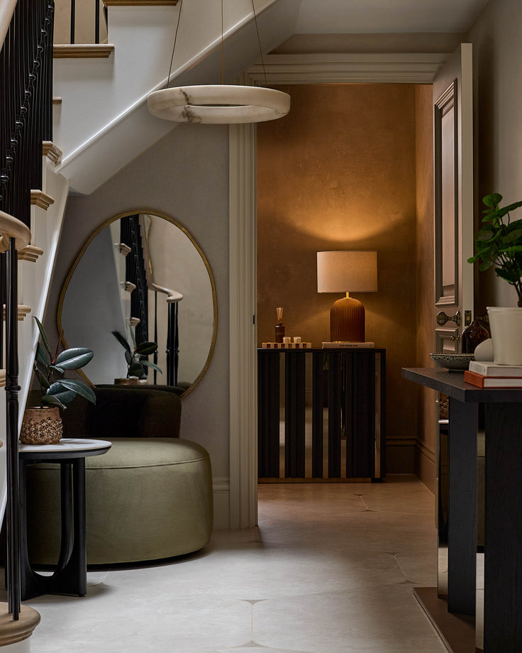 Black wooden sideboard with vertical slat design, displayed in modern hallway setting with warm bronze accent wall.