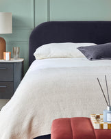 Bedroom setup with bed, bedside table, lamp, and stylish decor in calming hues. Perfect for a tranquil retreat.