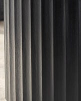 Close-up of a fluted black wooden furniture leg. Strong vertical lines and textured finish.