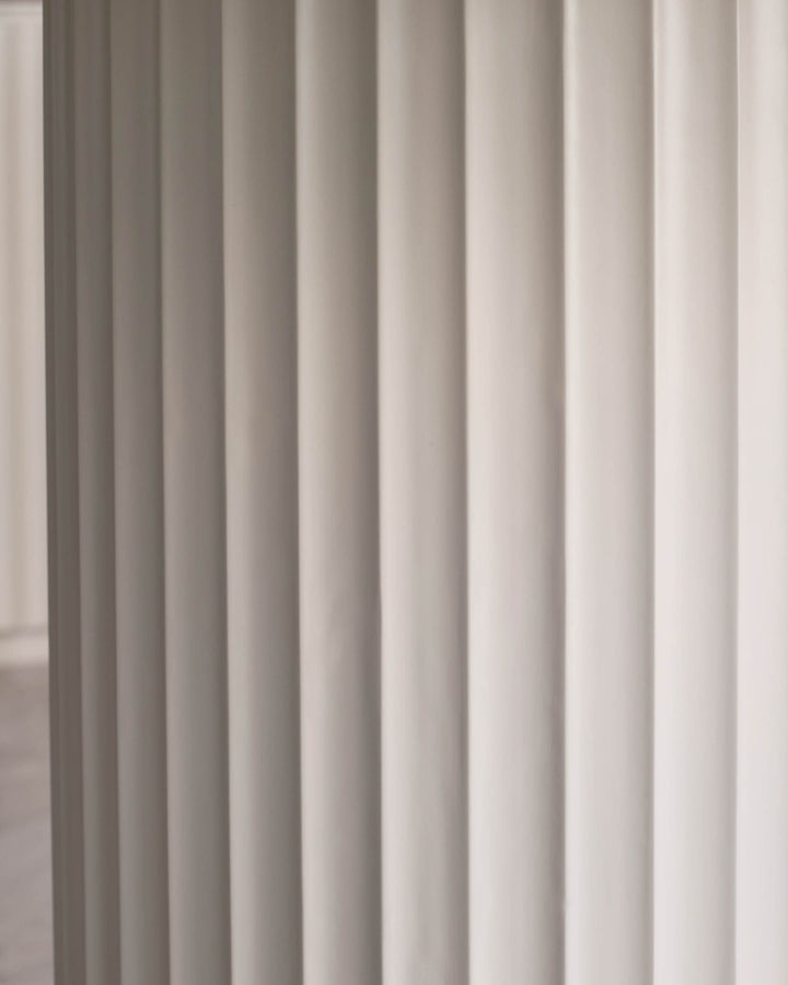 Close up of vertical, cream fluted wall panels. Modern texture and linear design.