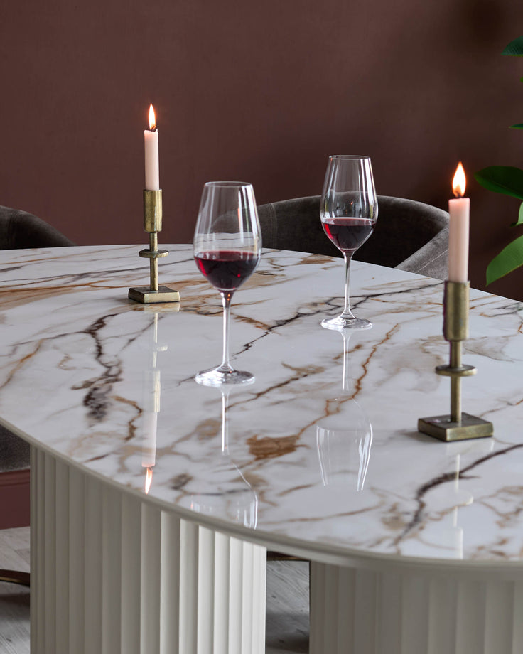 A marble table with two wine glasses and candles, creating a luxurious dining ambiance. Chairs are visible at the rear.