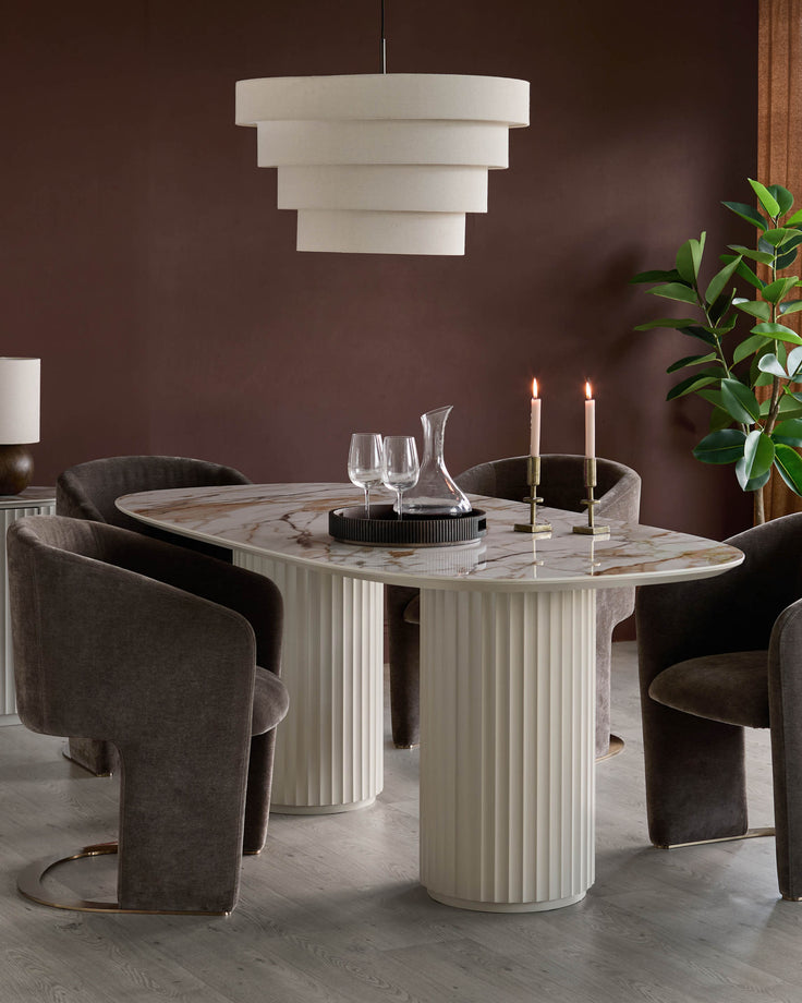 Dining set with a marble-topped table and plush chairs, illuminated by a tiered light fixture. Modern, stylish and elegant.